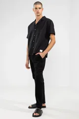 Pantalón de pana negro con cintura elástica y cordón de algodón. Cuenta con bolsillos laterales, un bolsillo trasero y el parche característico de Polonio.