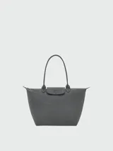 Bolso tote grande Le Pliage One de Longchamp, color negro, con asas superiores y solapa de cierre con botón a presión.