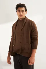 Cardigan marrón tejido con cuello smoking, cierre con botón y bolsillos delanteros.