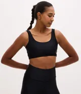Top deportivo Get Over de escote redondo y breteles anchos, confeccionado en microfibra texturizada. Diseño liso sin copas, ideal para entrenamiento de alto rendimiento.