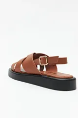 Sandalias color beige con capellada entrelazada y agarre ajustable en el talón. Plataforma de 3cm de alto y suela negra.