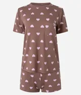 Pijama corto de dos piezas compuesto por una remera de manga corta con cuello redondo y bolsillo frontal, y un short de cintura elastizada. Ambos presentan un diseño estampado de corazones sobre fondo marrón.