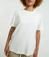 Remera de corte boxy con cuello redondo y mangas cortas. Confeccionada en algodón, presenta un diseño minimalista sin estampas con sisa caída.