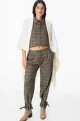 Ruana de tejido suave y envolvente en color blanco, con diseño de corte amplio y terminación de flecos en el ruedo.