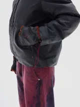 Campera verde con cuello de piel sintética blanca, cierre de botones a presión, bolsillos frontales y elástico en el dobladillo inferior. El forro interior es de algodón estampado.