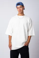 Remera de corte oversize, color blanco, con cuello redondo y mangas cortas amplias.