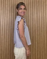 Musculosa a rayas verdes y blancas, con cuello alto fruncido, cierre frontal con botones y volados en los hombros.