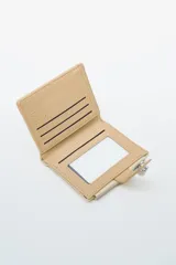 Billetera plegable color negro, con cierre a presión metálico en la solapa frontal. Presenta un panel superior con textura tejida y un panel inferior liso. Posee un bolsillo exterior con cierre metálico plateado en la parte inferior.