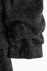 Blazer entallado de mezcla de viscosa en color negro, con solapas de muesca, hombreras y mangas tres cuartos fruncidas. Cuenta con bolsillos delanteros con solapa, diseño sin cierre y forro interior.