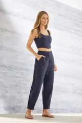 Pantalón de vestir azul marino, de corte recto, con bolsillos laterales y traseros. Se ajusta a la cintura con cinturón de cuero marrón.