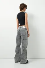 Jean de corte carpenter, estilo wide leg y tiro bajo, en color gris lavado. Presenta diseño de bolsillos frontales tipo parche y costuras reforzadas.