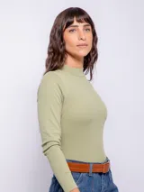 Polera blanca de cuello alto ajustada al cuerpo, con mangas largas y detalle de botones en los puños.
