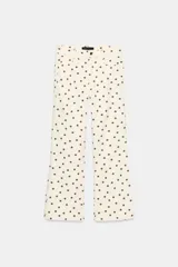 Jeans de tiro medio con diseño de cinco bolsillos, corte mini flare y bajo evasé. Presenta un estampado de lunares en contraste.