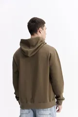 Canguro oversize de algodón, color negro, con capucha ajustable, bolsillo frontal tipo canguro y estampa sutil en el pecho.