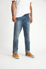 Jean de calce recto, color azul medio, con terminación arremangada.