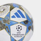 Balón de fútbol Adidas League Stage, réplica del balón oficial de la UEFA Champions League 25/26. Diseño principal blanco con paneles en forma de estrella en azul y detalles dorados, incluyendo ilustraciones de un carnero (signo zodiacal) y elementos astronómicos.