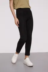 Calza de tiro alto confeccionada en material tipo gamuza, con corte ajustado al cuerpo y costuras verticales decorativas en el frente.