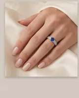Anillo de plata 925 con diseño de doble banda pavé y una piedra central circular de circonia azul.
