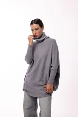Sweater de punto color gris, con cuello polera amplio y diseño oversize de silueta fluida y caída liviana.