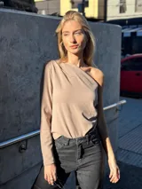 Top color visón con un solo hombro y manga larga.