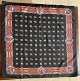 Pañuelo de seda negro con diseño estampado de caballos y bordes ornamentados en tonos rojos, blancos y beige.