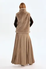 Chaleco de piel sintética con textura suave y efecto peludo, cuello elevado, cierre frontal con cremallera y bajo con elástico oculto para un ajuste abullonado.