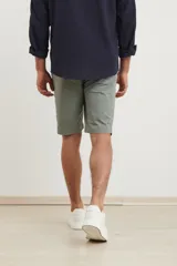 Bermuda de gabardina color verde medio, corte recto y largo a la rodilla.