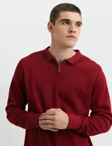 Remera de punto canalé francés con cuello polo, manga larga y cierre frontal de metal con tirador personalizado.