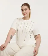 Remera de viscolycra color crudo, de corte regular, con cuello redondo, mangas cortas y apliques de lentejuelas verticales.