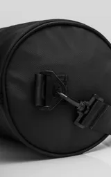 Bolso cilíndrico porta yoga-mat color negro, confeccionado en cordura de alta densidad. Cuenta con correas regulables grabadas con el logo de la marca, manijas cortas para agarre manual, compartimento principal con cierre metálico reforzado y un bolsillo trasero pequeño con cierre para objetos de valor.