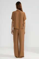 Pantalón de crepe color marrón, de corte recto con cintura elastizada y bolsillos laterales.