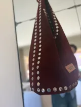 Bolso negro de gamuza con tachas plateadas.