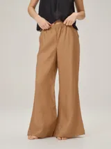 Pantalón de lino color tostado, de corte amplio y fluido con piernas acampanadas.