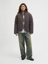 Campera acolchada de color gris oscuro, con diseño matelaseado de ondas, cuello alto en rib, cierre frontal con cremallera metálica y bolsillos frontales aplicados.