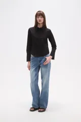 Camisa de algodón negra, de corte entallado, con cuello clásico y cierre frontal de botones.