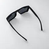 Lentes de sol polarizados con armazón de acetato gris translúcido y diseño cuadrado, con cristales oscuros.