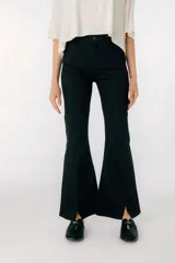 Pantalón jean tiro alto de corte flared, color celeste claro, con diseño ajustado en las piernas y aberturas en el dobladillo inferior.