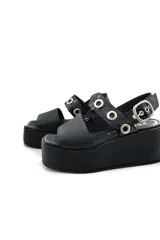 Sandalia negra de cuero con plataforma y ajuste con hebilla.