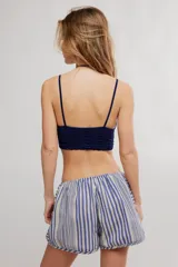 Bralette de encaje negro con copas triangulares, escote festoneado, tirantes finos regulables y banda inferior elastizada.