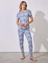Conjunto de pijama marca Jesica Simpson, confeccionado en tejido soft con estampado floral en tonos azul y rosa. Incluye remera de manga corta con escote redondo y pantalón largo con cintura elastizada y lazo de ajuste.