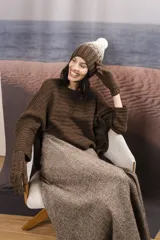Gorro de punto degradé en tonos marrón y blanco, con diseño tejido en canalé y pompón superior claro.
