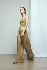 Pantalón marrón con rayas sutiles, de corte ancho y relajado, cintura ajustable con cordón y doble volado fruncido en el ruedo.
