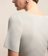 Blusa de manga corta confeccionada en tejido de viscosa texturizado, con escote en V profundo que presenta un detalle de aro metálico central.