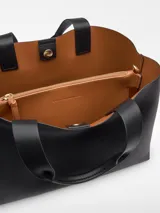 Bolso shopper horizontal de poliuretano color beige, con dos compartimentos, cierre magnético, bolsillo interior con cierre, asa de mano y asa larga regulable y extraíble. Incluye logo grabado en el frente.