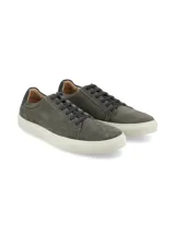 Championes urbanos de gamuza en color gris, con cordones al tono y suela de goma blanca. Presenta un detalle de cuero oscuro en el talón.
