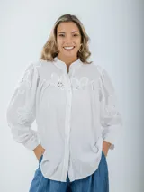 Camisa blanca de broderie con estilo boho y romántico, manga larga levemente abullonada.
