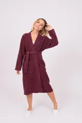 Bata de polar color coral, con cuello esmoquin, mangas largas y lazo para ajustar en la cintura.
