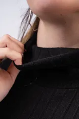 Polera de cuello alto y manga larga, confeccionada en tejido de punto acanalado con estampado de cebra en blanco y negro.