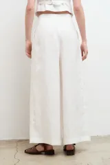 Pantalón blanco de lino, de corte palazzo, tiro alto y pierna ancha.