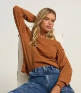 Suéter boxy básico color marrón, confeccionado en punto leve, con cuello redondo y mangas largas con puños y bajo canelados.